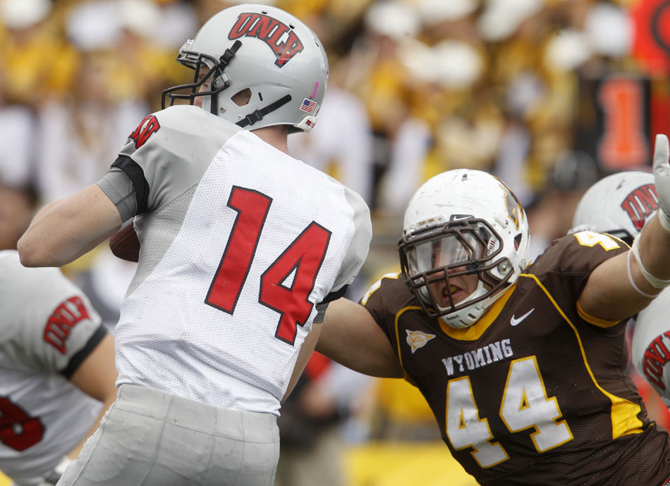 Wyoming defensive end Josh Biezuns prepares to lay a hit on UNLV quarterback Sean Reilly during a NCAA college football game on Saturday, Oct. 15, 2011, in Laramie, Wyo.