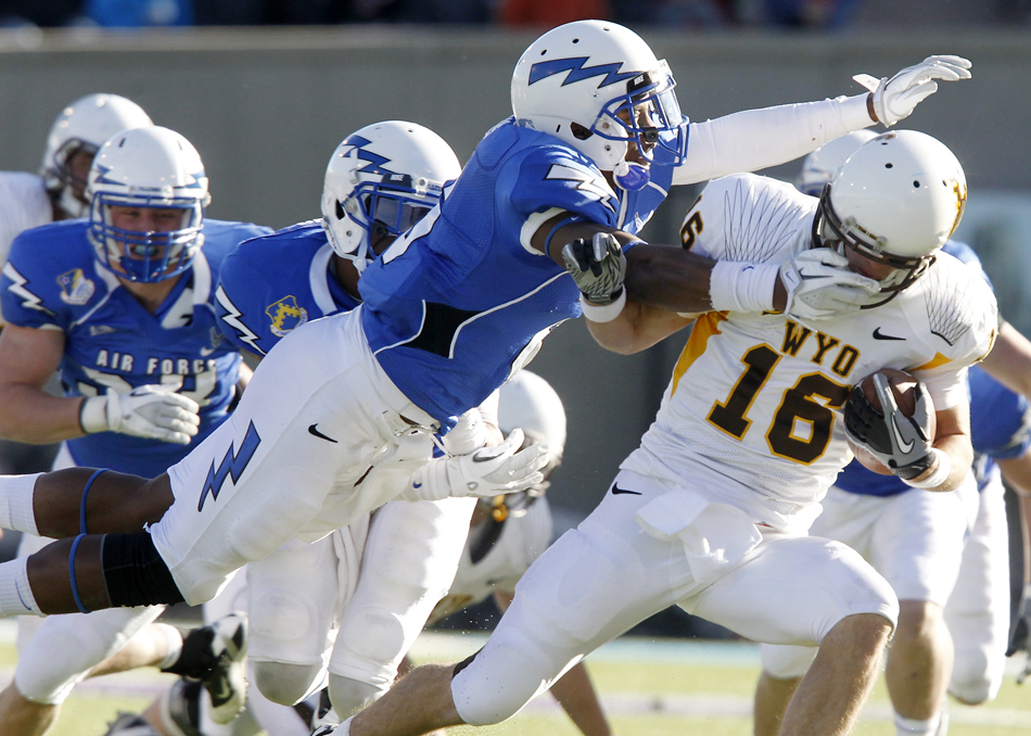 Air Force defensive back Jon Davis, left, grabs Wyoming quarterback Brett Smith by the face mask during a NCAA college football game on Saturday, Nov. 12, 2011, at Falcon Stadium in Colorado Springs, Colo.  Smith fumbled the ball on the play, but a face mask penalty allowed the Wyoming drive to continue.