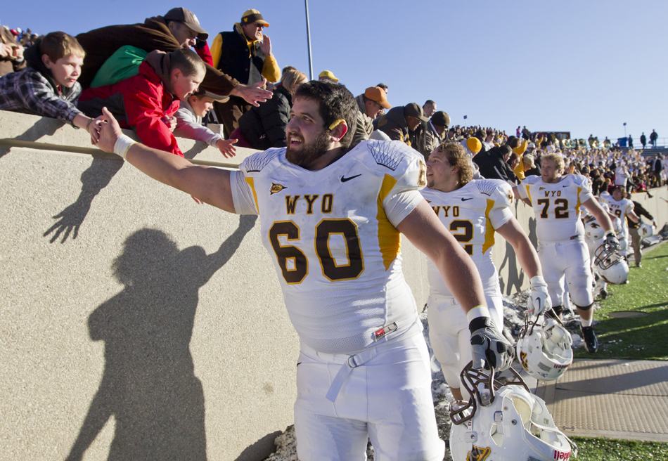 Wyoming center Nick Carlson high fives fans after a 25-17 win against Air Force on Saturday, Nov. 12, 2011, at Falcon Stadium in Colorado Springs, Colo.