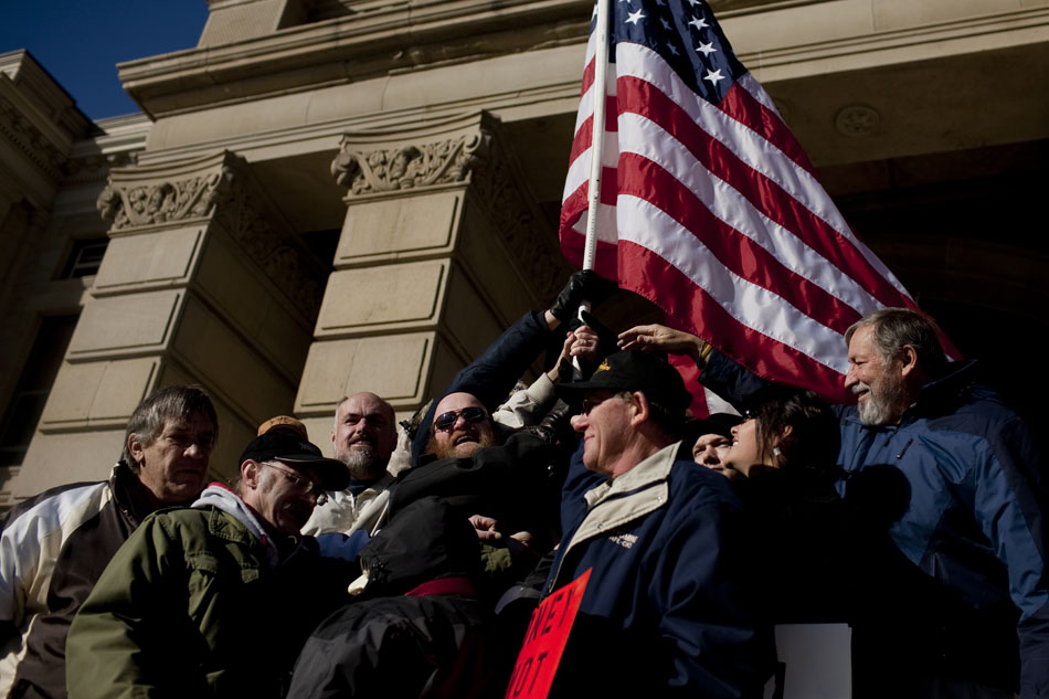 Occupy Cheyenne protestors hold an American flag on the steps of the Wyoming State Capitol on Saturday, Dec. 10, 2011, in Cheyenne.