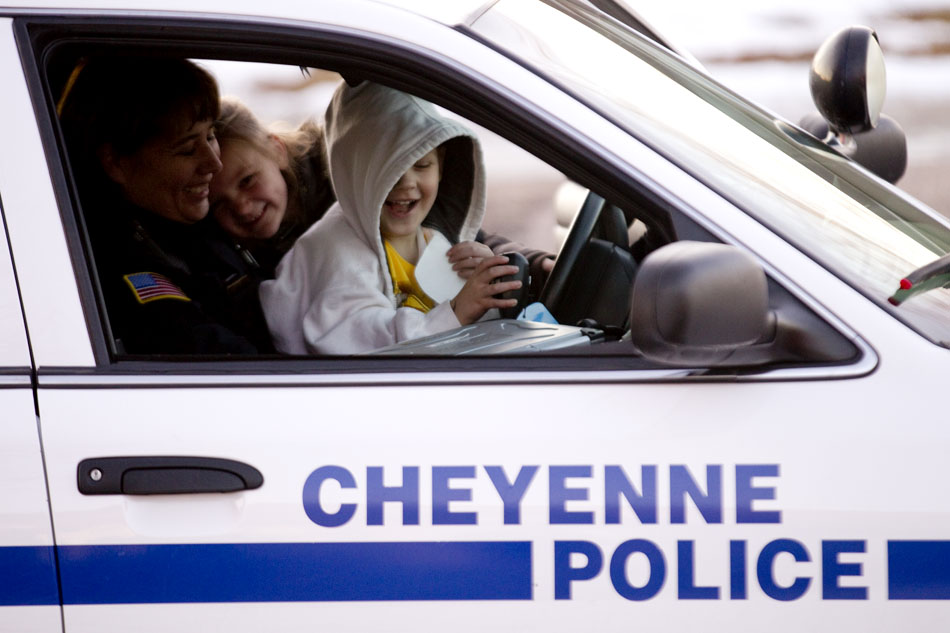 Collin Pickens, 4, right reacts as he and his sister, Jayden, 7, play with the sirens in a Cheyenne Police Department car on Thursday, Dec. 15, 2011, in south Cheyenne. Cheyenne Police officers, Cheyenne firefights and Santa Claus stopped by to drop off toys donated to the Pickens family following a Dec. 1 fire that destroyed their apartment. Members of the community donated $1,500 in cash and gift cards to the family and Cheyenne Fire Local 279 bought and wrapped toys.