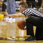 A NCAA official gives a high five to a youngster serving as an honorary tip off kid before a game between Wyoming and BYU on Wednesday, Feb. 2, 2011, in Laramie, Wyo. (James Brosher/Wyoming Tribune Eagle)