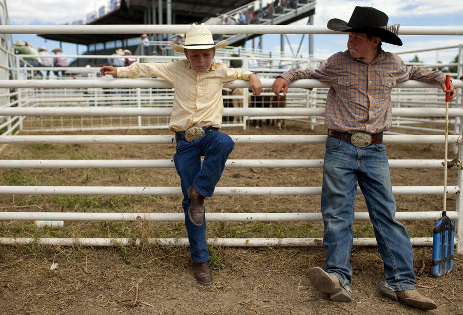 Jack Osborn, left, 10, and Brayden Wiesen, 11, take a break towards the end of the day inside of a chute during the first go of slack tie-down roping on Wednesday, July 20, 2011, at Frontier Park. Several youngsters including the two funneled cattle into chute 9 from 8 a.m. to about noon for slack tie-down roping. (James Brosher/Wyoming Tribune Eagle)