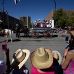 A family watches as a covered wagon passes the intersection of Capitol Avenue and 21st Street during the Cheyenne Frontier Days parade on Saturday, July 23, 2011, in downtown Cheyenne. (James Brosher/Wyoming Tribune Eagle)