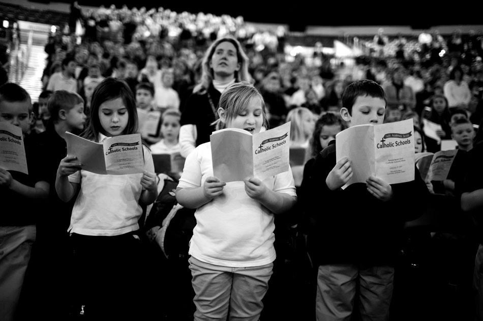 Riley Niedbalski, left, Sarah Wood and Harley Pankiewicz, all 6 year olds from Mishawaka Catholic School sing during the All Schools Mass on Monday, Feb. 27, 2012, in the Purcell Pavilion at the University of Notre Dame. (James Brosher/South Bend Tribune)