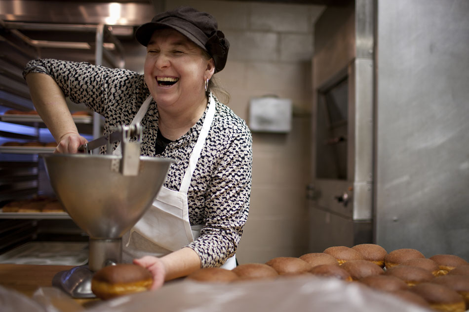 Marysia Rzeszutek shares a laugh with a family member as she adds a raspberry filling to a paczki, a type of cream-filled Polish pastry, on Monday, Feb. 20, 2012, at Baker's Dozen Bake Shop in South Bend. Rzeszutek and her husband, Chris, own the shop and expect to make between 2,500 and 3,000 paczkis for Fat Tuesday. The pastries are a traditional treat for Polish Catholics before lent. (James Brosher/South Bend Tribune)
