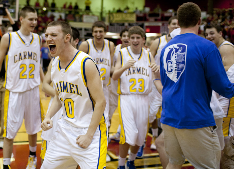 Carmel's James Crowley runs into the awaiting arms of fans as they storm the court following a 62-59 win against Elkhart Memorial in a Class 4A semistate on Saturday, March 17, 2012, at Huntington North High School in Huntington, Ind. Carmel survived after a half-court heave at the buzzer by Elkhart Memorial fell a few feet short of the rim. (James Brosher/South Bend Tribune)