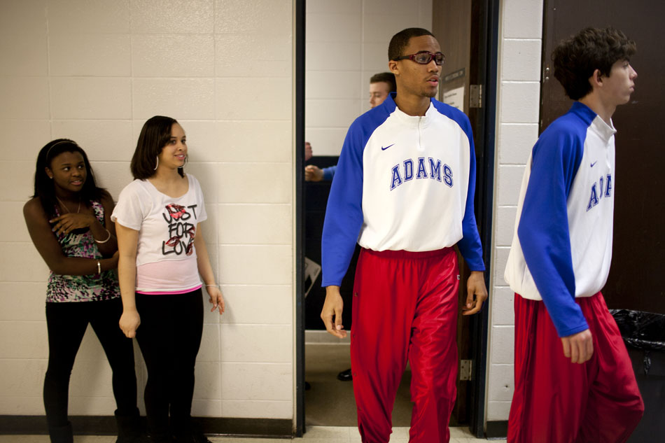 A couple curious fans watch as Adams players, including Nolan Montgomery, center, exit the locker room before a Class 4A basketball regional semi-final on Saturday, March 10, 2012, at Michigan City High School. (James Brosher/South Bend Tribune)