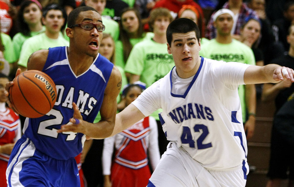 Adams' Nolan Montgomery, left, reacts as he drives the baseline in front of Lake Central's Taylor Lehnert during a Class 4A basketball regional semi-final on Saturday, March 10, 2012, at Michigan City High School. (James Brosher/South Bend Tribune)
