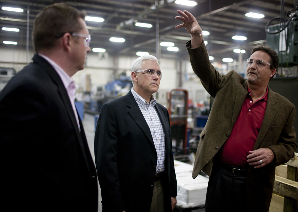 Larry Davis, right, president of Daman Products, points out a machine as he gives a tour of the facility to U.S. Rep. Mike Pence, R-Ind., and local business leaders and officials on Friday, March 16, 2012, at the Mishawaka manufacturing company. Pence was in town as part of a statewide tour meeting with businesses as he runs for governor. (James Brosher/South Bend Tribune)