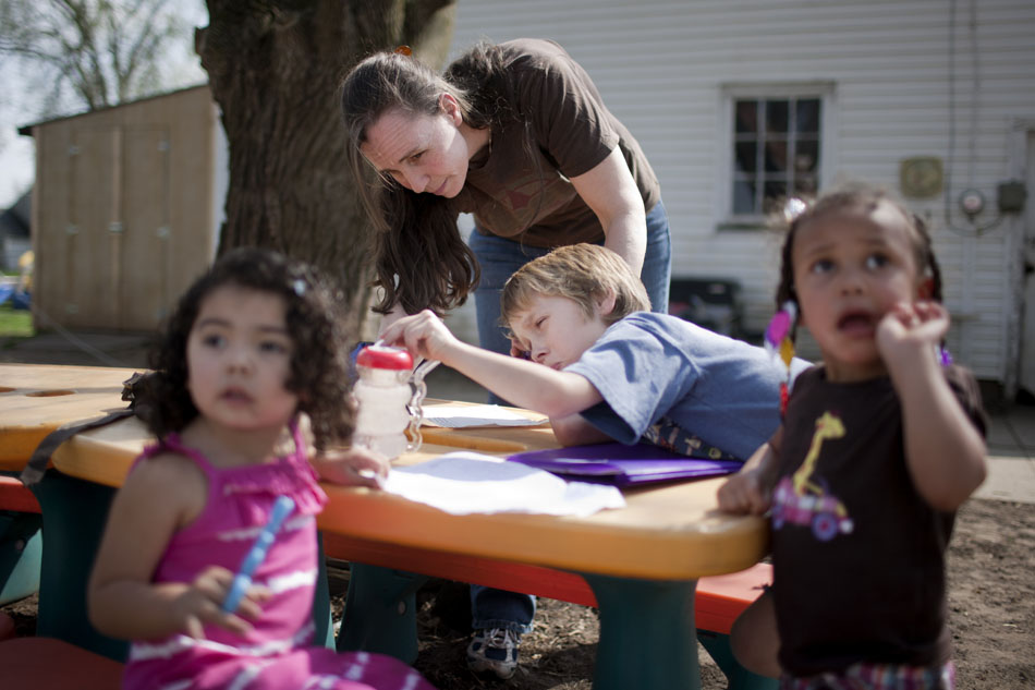 Julia Frick helps Matthew Frick with some homework on Thursday, March 22, 2012, in the backyard of her Elkhart home. (James Brosher/South Bend Tribune)