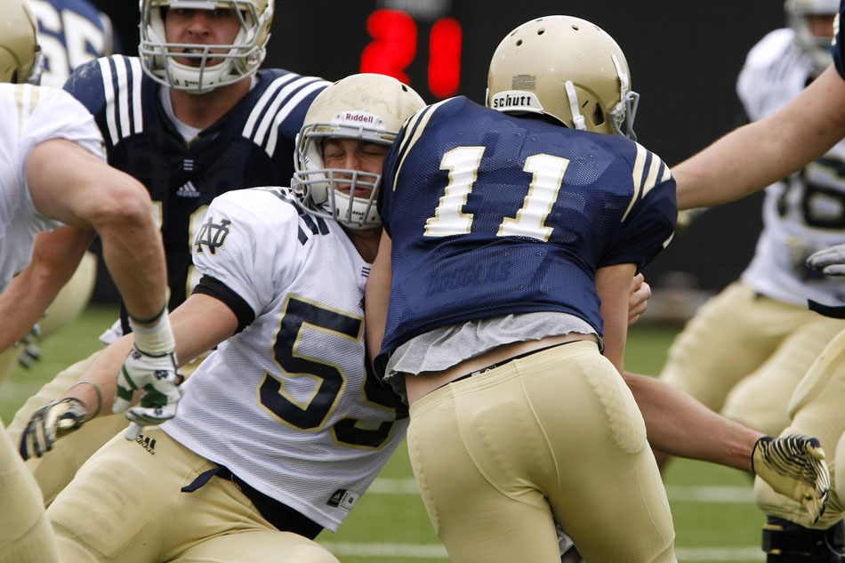 Notre Dame linebacker Jarrett Grace (59) lays a hit on quarterback Tommy Rees during a football practice on Saturday, April 14, 2012, at Notre Dame. (James Brosher/South Bend Tribune)