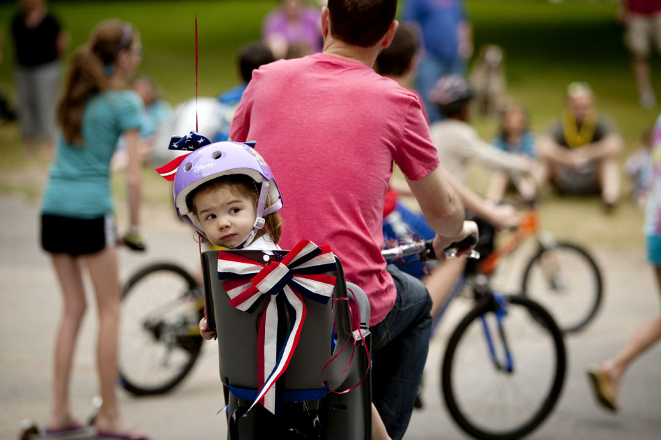 Stella Hall, 2, glances back at parade participants behind her as she rides with her father, Bryan, in a community Memorial Day parade on Saturday, May 26, 2012, morning in Granger. The parade started at the home of Dr. Mark Lavallee in the Farmington Square subdivision. (James Brosher/South Bend Tribune)