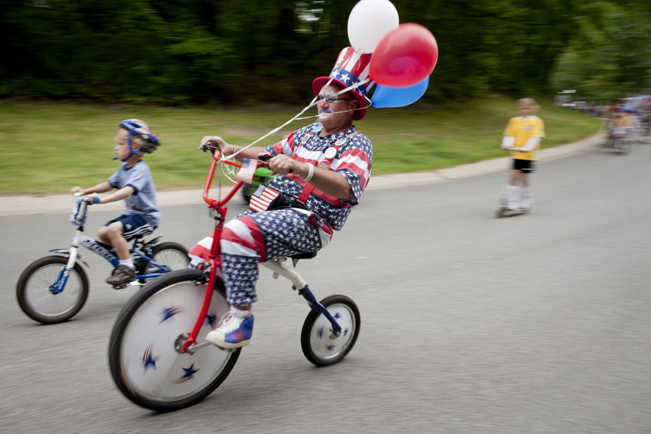 Barry Naragon, also known as Sparky the Clown, speeds down a hill with a group of young cyclists during a community Memorial Day parade on Saturday, May 26, 2012, morning in Granger. The parade started at the home of Dr. Mark Lavallee in the Farmington Square subdivision. (James Brosher/South Bend Tribune)