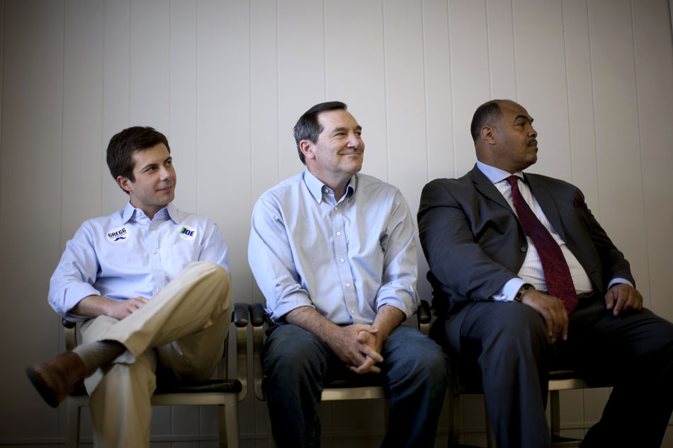 South Bend mayor Pete Buttigieg, left, U.S. Rep. Joe Donnelly, D-Ind., and the Rev. Rickardo Taylor Sr. from Mt. Carmel Missionary Baptist, listen to a speaker on stage during a "Workhorse Tour" stop on Saturday, May 19, 2012, at UAW Local 9 in South Bend. (James Brosher/South Bend Tribune)