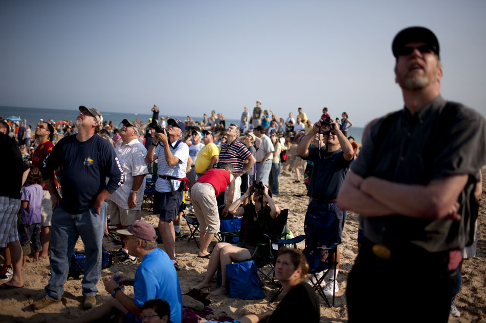 Crowd members watch as WWII-era planes fly over the beach during a re-enactment on Saturday, June 30, 2012, at Tiscornia Beach in St. Joseph, Mich. (James Brosher/South Bend Tribune)