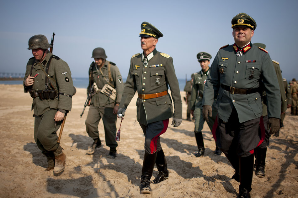 A re-enactor portraying German dictator Adolf Hilter, center, makes his way along the beach before a WWII re-enactment on Saturday, June 30, 2012, at Tiscornia Beach in St. Joseph, Mich. (James Brosher/South Bend Tribune)