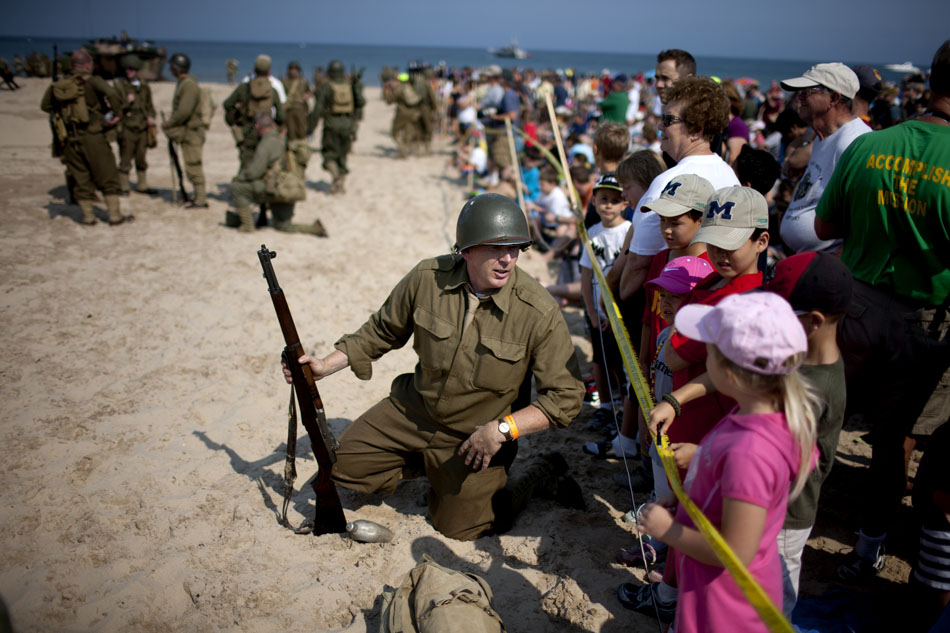A U.S. re-enactor talks with the crowd after a WWII re-enactment on Saturday, June 30, 2012, at Tiscornia Beach in St. Joseph, Mich. (James Brosher/South Bend Tribune)