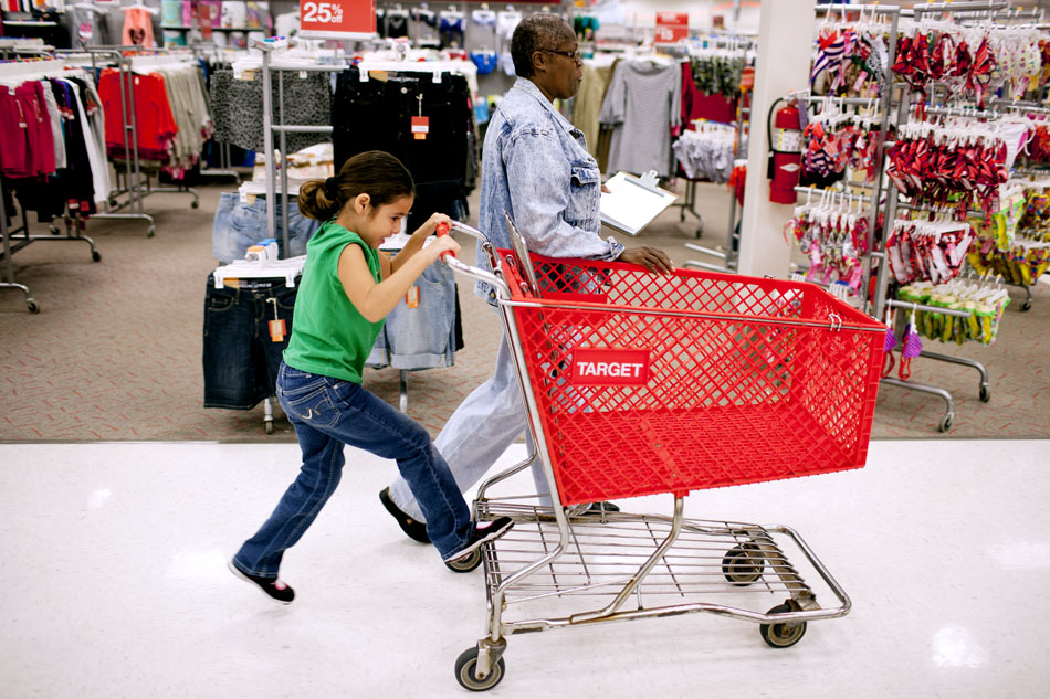 Leyla Garcia rides a shopping cart as she shops for supplies with volunteer Deb Franklin during a back to school shopping spree on Monday, Aug. 6, 2012, at the Super Target in Granger. Each of the 18 local children received an $80 gift card to use towards back to school supplies. (James Brosher/South Bend Tribune)