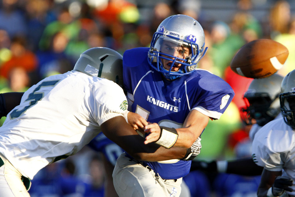Marian quarterback Vince Ravotto watches his pitch out fly through the air as he's hit by Washington's Devonte Hughes (5) during a high school football game on Friday, Sept. 14, 2012, at Marian High School in Mishawaka. (James Brosher/South Bend Tribune)