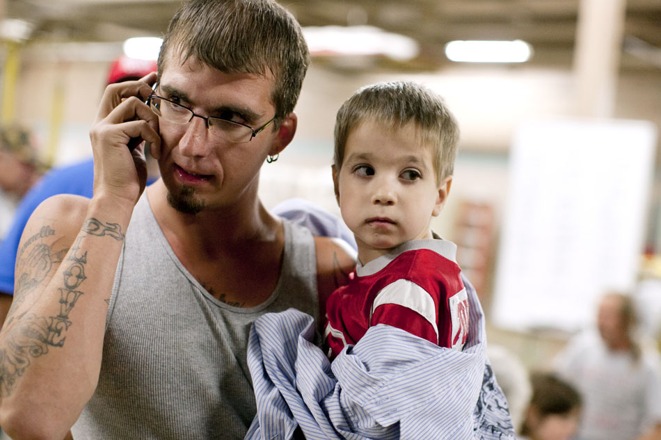 Jeffrey Scott, left, places a call as he holds his son, Joshua, after they were forced to evacuate their Fourth Street home on Friday, Sept. 14, 2012, at the Mishawaka Fire Station. Police and firefighters evacuated a large area of Mishawaka after a reported chemical fire. (James Brosher/South Bend Tribune)