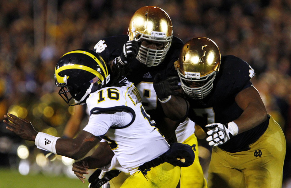 Notre Dame defensive lineman Louis Nix III (9) and defensive end Stephon Tuitt (7) pressure Michigan quarterback Denard Robinson (16) during a NCAA college football game on Saturday, Sept. 22, 2012, at Notre Dame. Robinson threw an interception on the play. (James Brosher/South Bend Tribune)