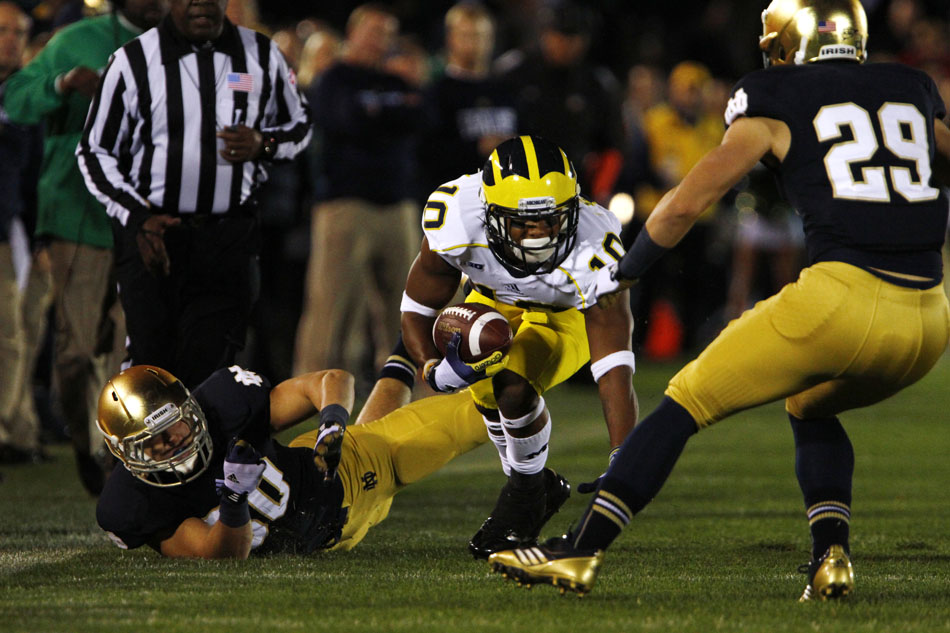 Michigan wide receiver Jeremy Gallon looks to make a move past Notre Dame linebacker Ben Councell, left, and safety Nicky Baratti during a NCAA college football game on Saturday, Sept. 22, 2012, at Notre Dame. (James Brosher/South Bend Tribune)