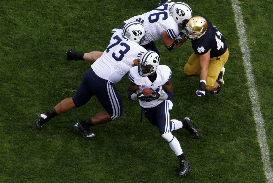 Brigham Young running back Jamaal Williams, bottom, avoids a tackle from Notre Dame linebacker Carlo Calabrese, right, as he gets to the edge on a rushing attempt during a NCAA college football game on Saturday, Oct. 20, 2012, at Notre Dame. (James Brosher/South Bend Tribune)