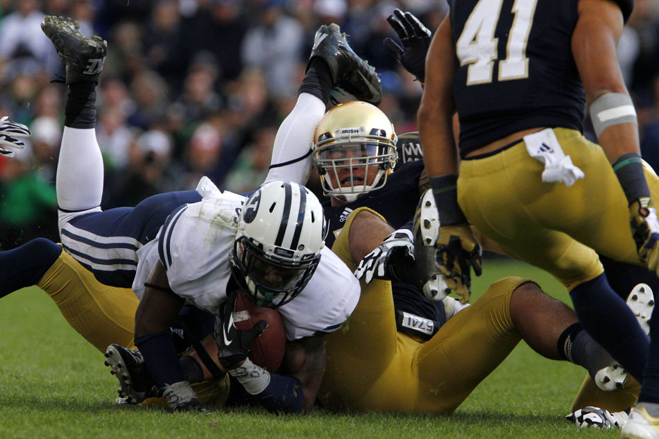 Notre Dame linebacker Manti Te'o, center, brings down Brigham Young running back Jamaal Williams during a NCAA college football game on Saturday, Oct. 20, 2012, at Notre Dame. (James Brosher/South Bend Tribune)