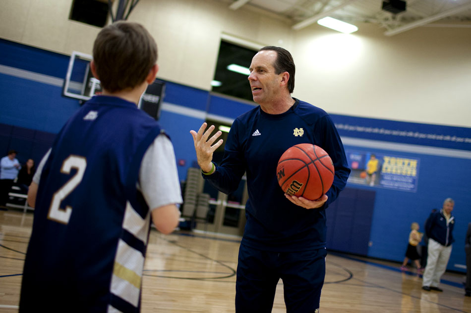 Notre Dame coach Mike Brey challenges some youngsters to hit free-throws after an open practice on Tuesday, Oct. 23, 2012, at the Kroc Center in South Bend. (James Brosher/South Bend Tribune)