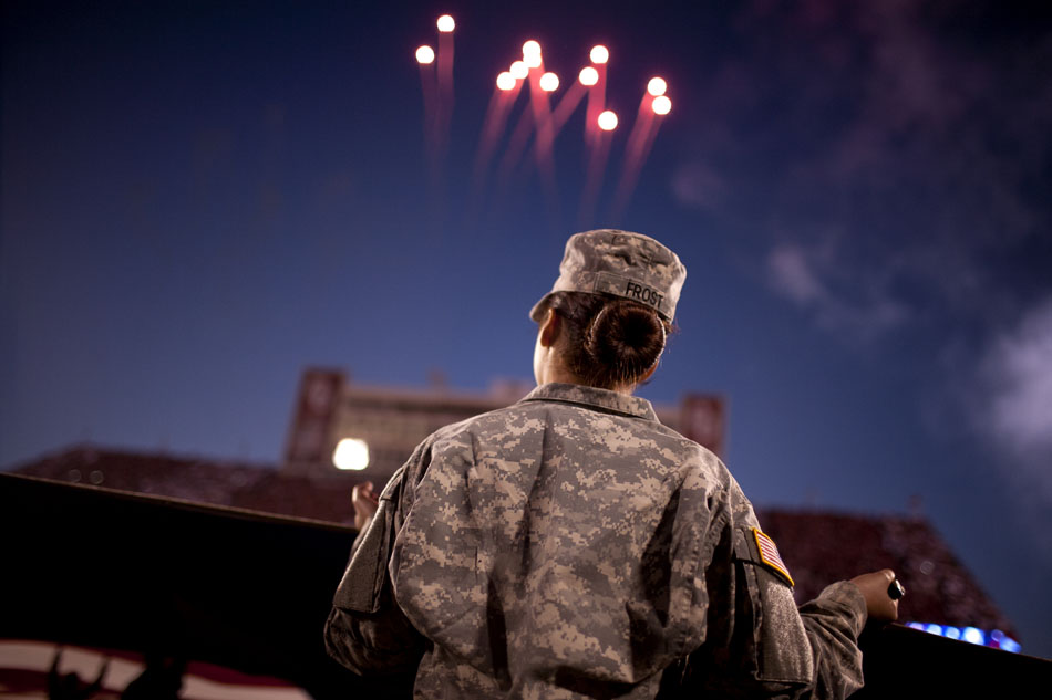 Fireworks explode over the stadium after the National Anthem as one of several soldiers holds a field-sized American flag before an NCAA college football game between Notre Dame and Oklahoma on Saturday, Oct. 27, 2012, in Norman, Okla. (James Brosher/South Bend Tribune)