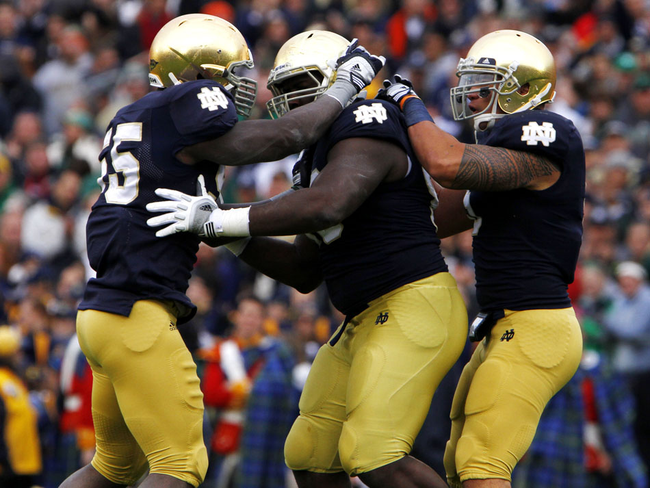 Notre Dame linebacker Prince Shembo, left, and linebacker Manti Te'o celebrate with defensive end Kapron Lewis-Moore, center, after Lewis-Moore sacked the Pittsburgh quarterback during an NCAA college football game on Saturday, Nov. 3, 2012, at Notre Dame. (James Brosher/South Bend Tribune)