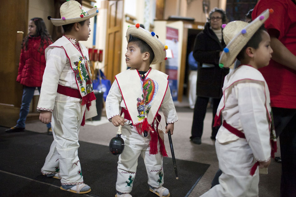 Ulysses Cardona, 3, looks back at the procession as he and his brothers Valentin, 7, left, and Alexis, 5, enter the church dressed as little Juan Diegos during a Matachines performance on Wednesday, Dec. 12, 2012, at St. Adalbert Parish in South Bend. (James Brosher/South Bend Tribune)