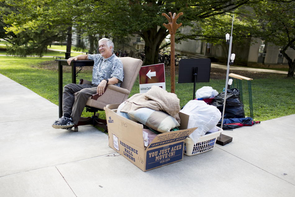 John Freed of Columbus shares a laugh as he relaxes as he watches his son's belongings on a sidewalk in front of Teter Quad during Indiana University Bloomington move-in day on Wednesday, Aug. 19, 2015. (James Brosher/IU Communications)