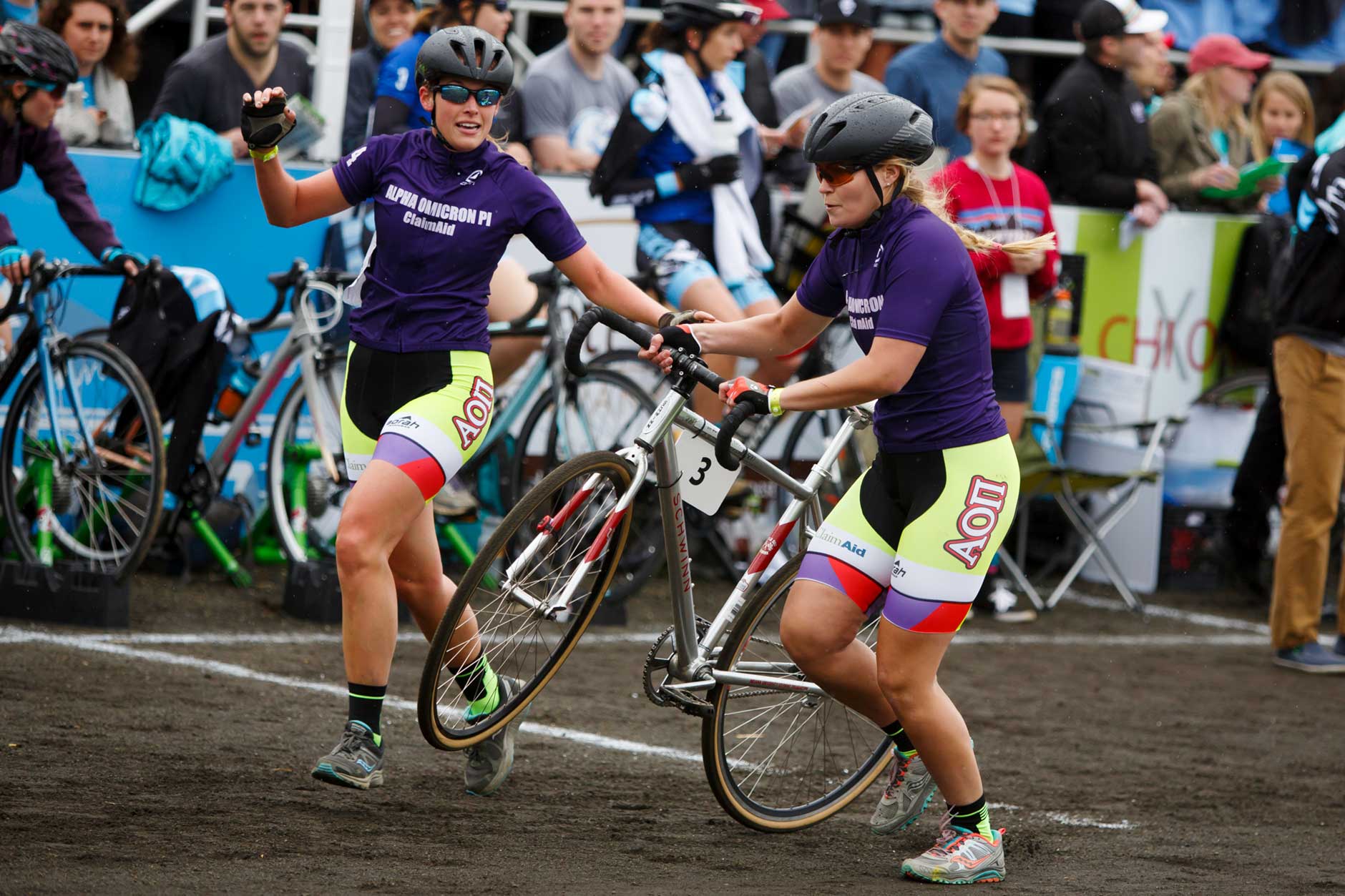 Alpha Omicron Pi's Ali Oppel, left, exchanges with teammate Leigh Dukeman during the Women's Little 500 at Bill Armstrong Stadium on Friday, April 21, 2017. (James Brosher/IU Communications)