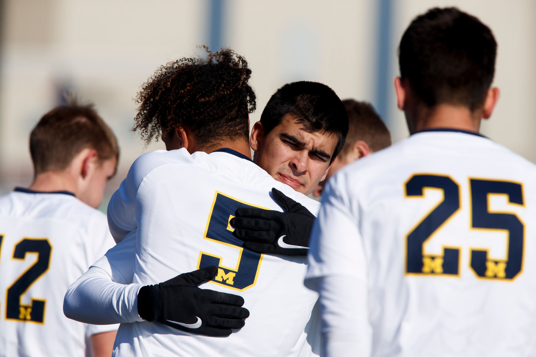 Michigan's Marc Ybarra, center, and Abdou Samake (5) hug before the Big Ten Men's Soccer Tournament championship game against Indiana at Grand Park in Westfield, Indiana on Sunday, Nov. 11, 2018. (Photo by James Brosher)