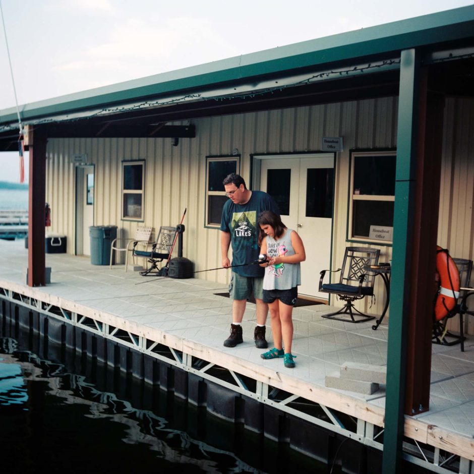 Alex Moonan and Hope Moonan fish off the dock at DreamChaser at Lake Ouachita, Arkansas on Thursday, Aug. 23, 2018. (Photo by James Brosher)
