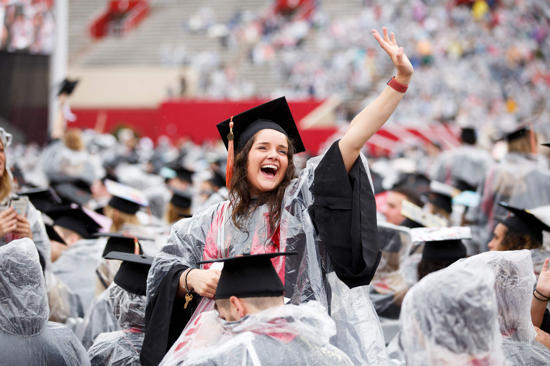 A graduate waves to friends in the audience during the Indiana University Bloomington Undergraduate Commencement at Memorial Stadium on Saturday, May 4, 2019. (James Brosher/Indiana University)