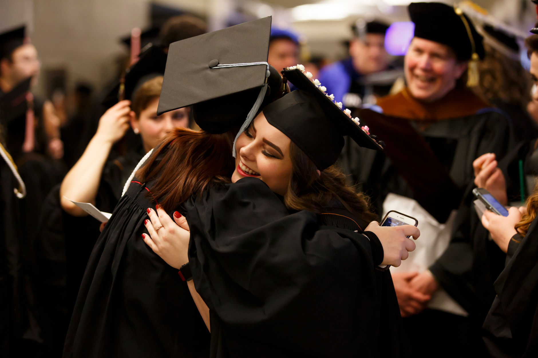 Indiana University Fort Wayne graduates share a hug before the Purdue Fort Wayne and IU Fort Wayne Commencement at the Allen County War Memorial Coliseum on Wednesday, May 8, 2019. (James Brosher/Indiana University)