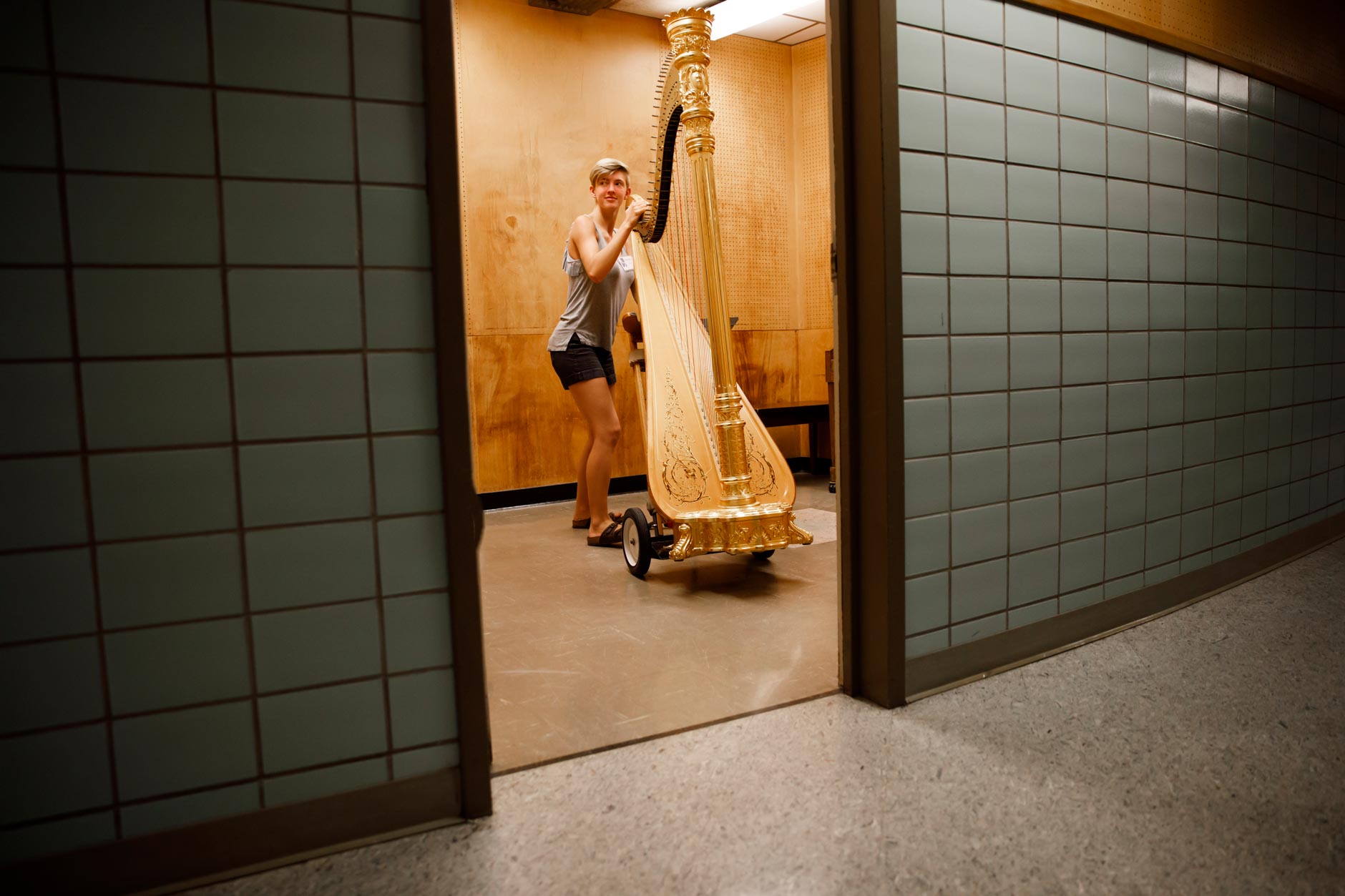Volunteer Chelsea Balmer moves a harp from a practice room during the 11th USA International Harp Competition at Indiana University in Bloomington, Indiana on Wednesday, July 3, 2019. (Photo by James Brosher)
