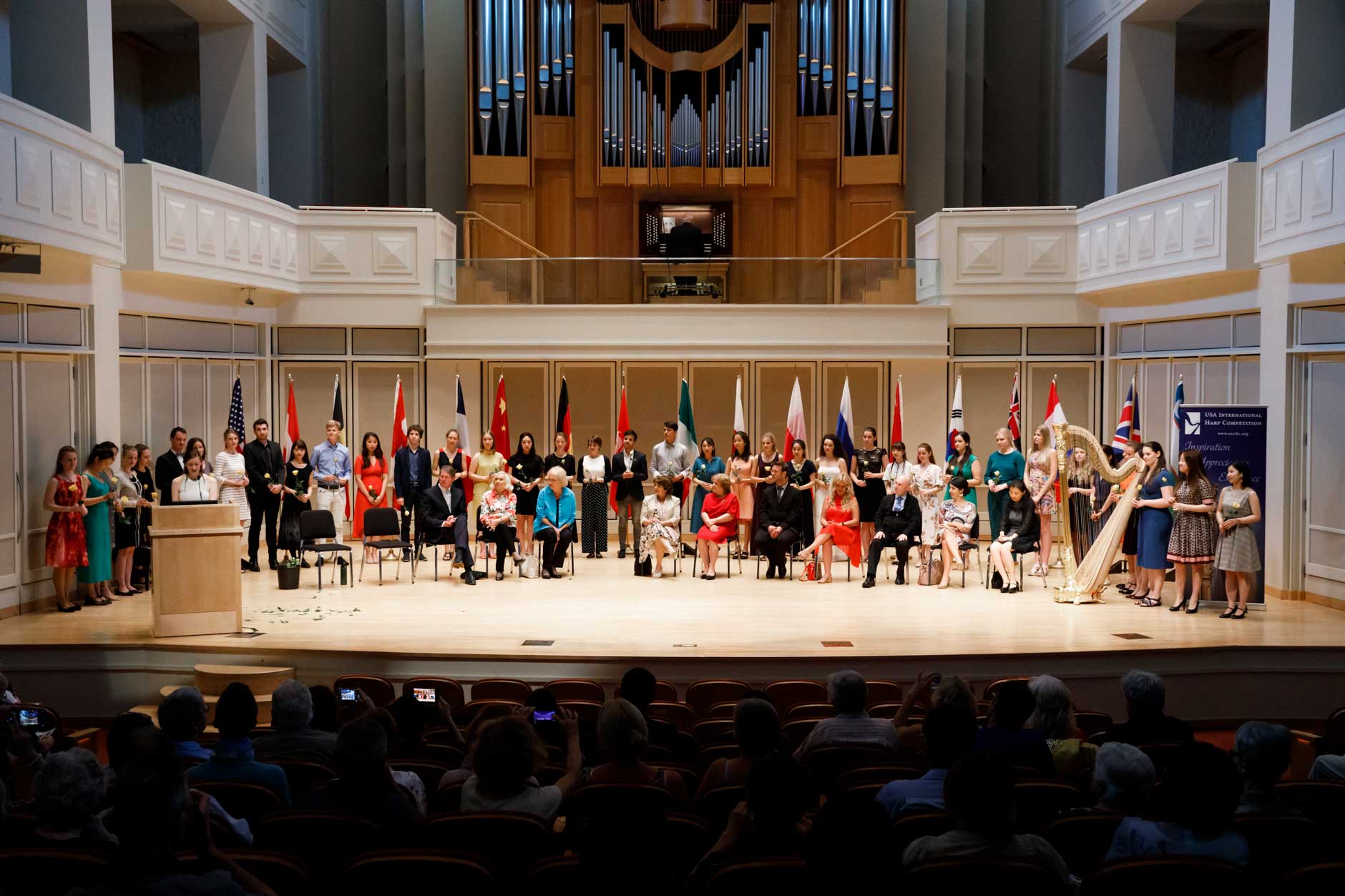 Contestants, special guests and jury members are pictured on stage during the opening ceremony of the 11th USA International Harp Competition at Indiana University in Bloomington, Indiana on Wednesday, July 3, 2019. (Photo by James Brosher)