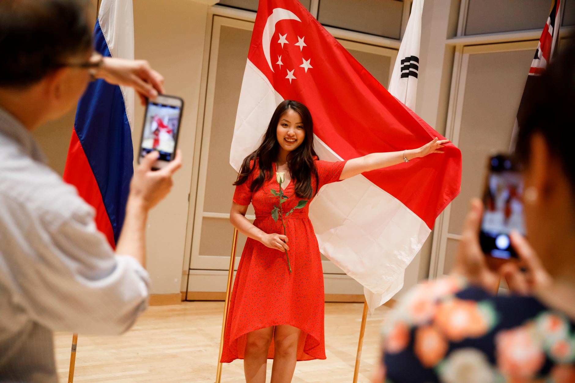 Nicolette Chin of Singapore poses with her country's flag after the opening ceremony of the 11th USA International Harp Competition at Indiana University in Bloomington, Indiana on Wednesday, July 3, 2019. (Photo by James Brosher)