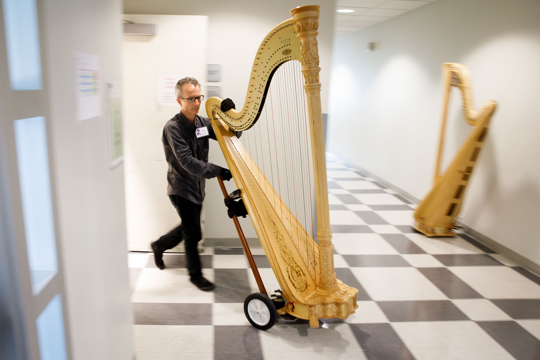 Lyon and Healy Technician John Papadolias moves a harp from a practice room to the stage during Stage III at the 11th USA International Harp Competition at Indiana University in Bloomington, Indiana on Wednesday, July 10, 2019. (Photo by James Brosher)