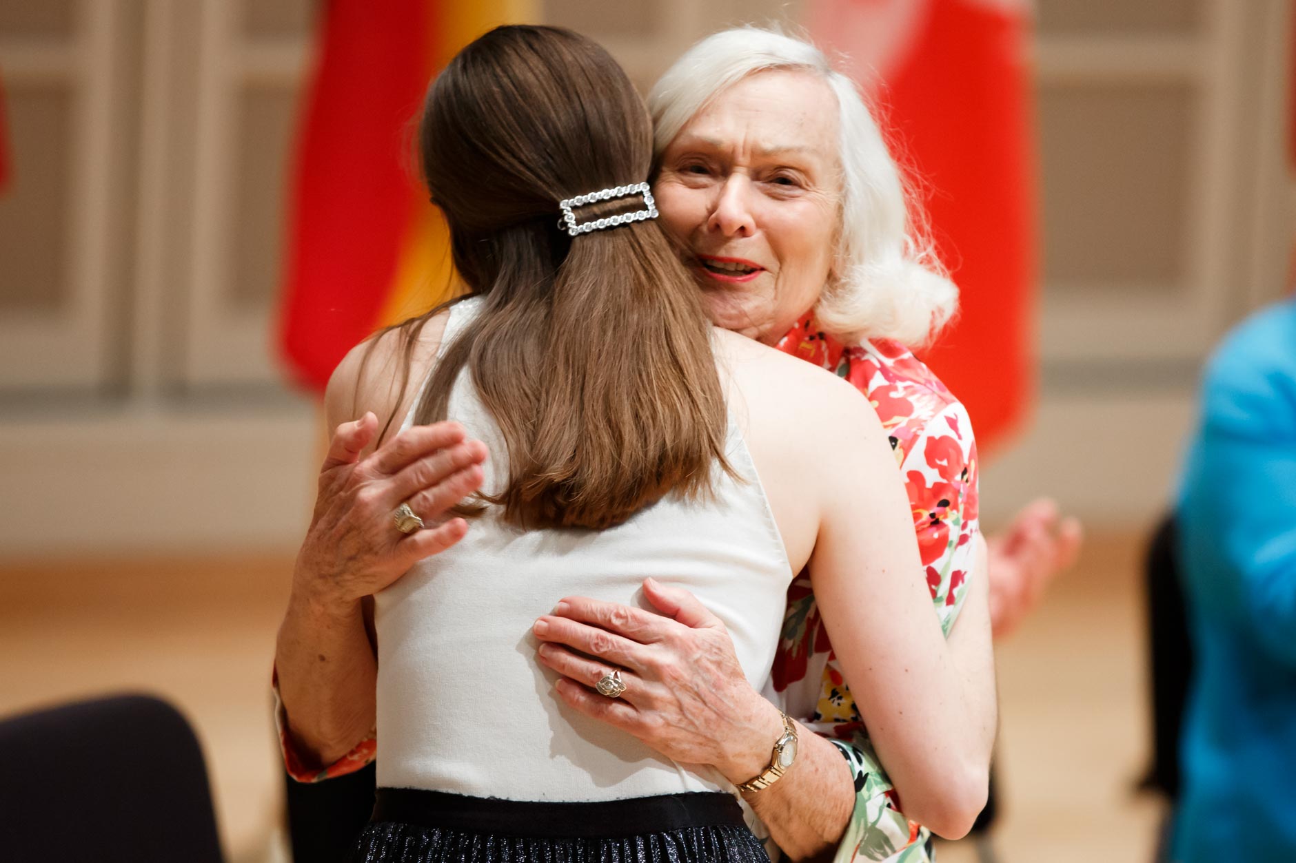 USA International Harp Competition Founder and Artistic Director Susann McDonald hugs Executive Director Erin Brooker-Miller during the opening ceremony of the 11th USA International Harp Competition at Indiana University in Bloomington, Indiana on Wednesday, July 3, 2019. (Photo by James Brosher)