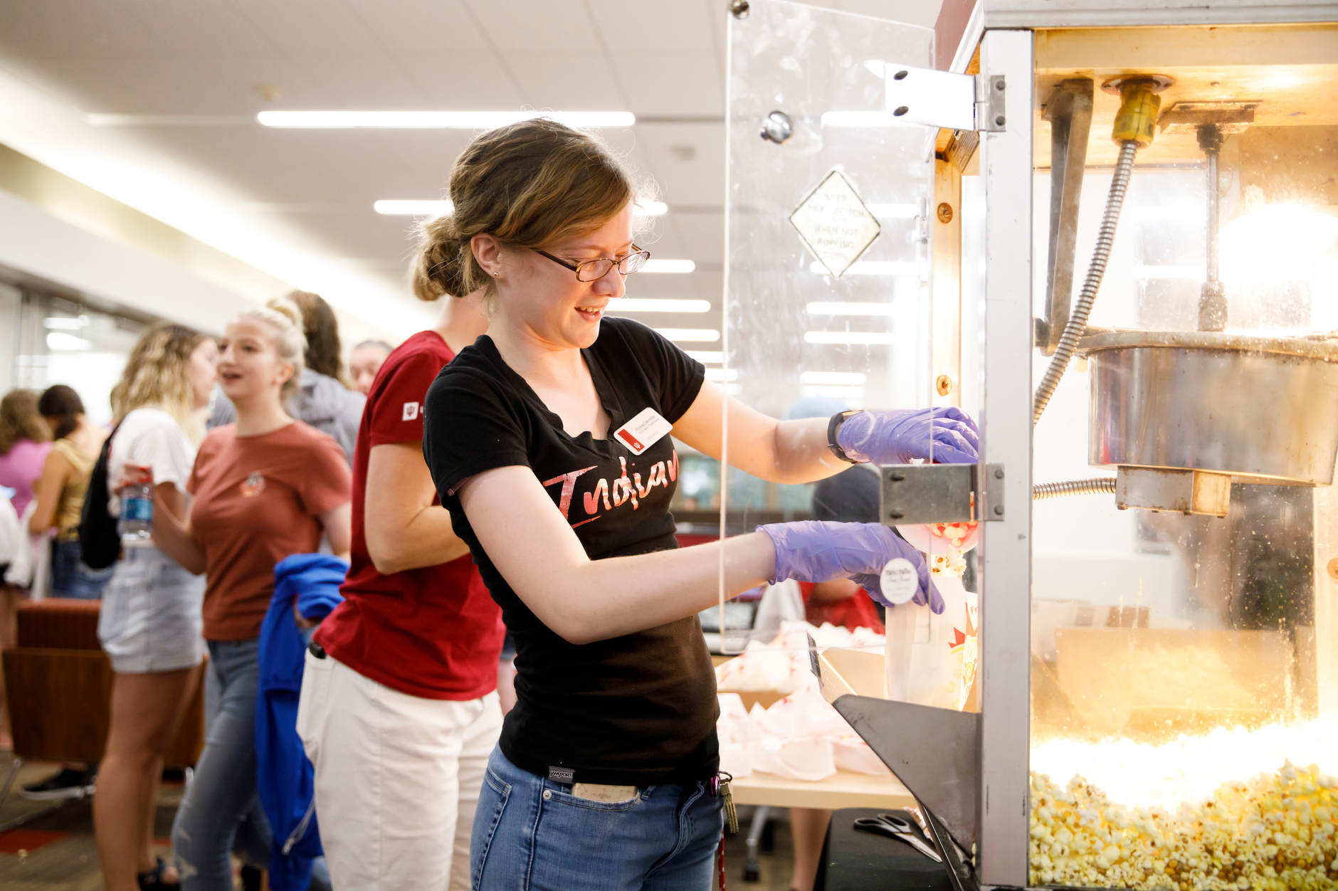 Indiana University Scholars' Commons Librarian Alyssa Denneler scoops popcorn during the Herman B House Party in the Wells Library at IU Bloomington on Thursday, Aug. 22, 2019. (James Brosher/Indiana University)