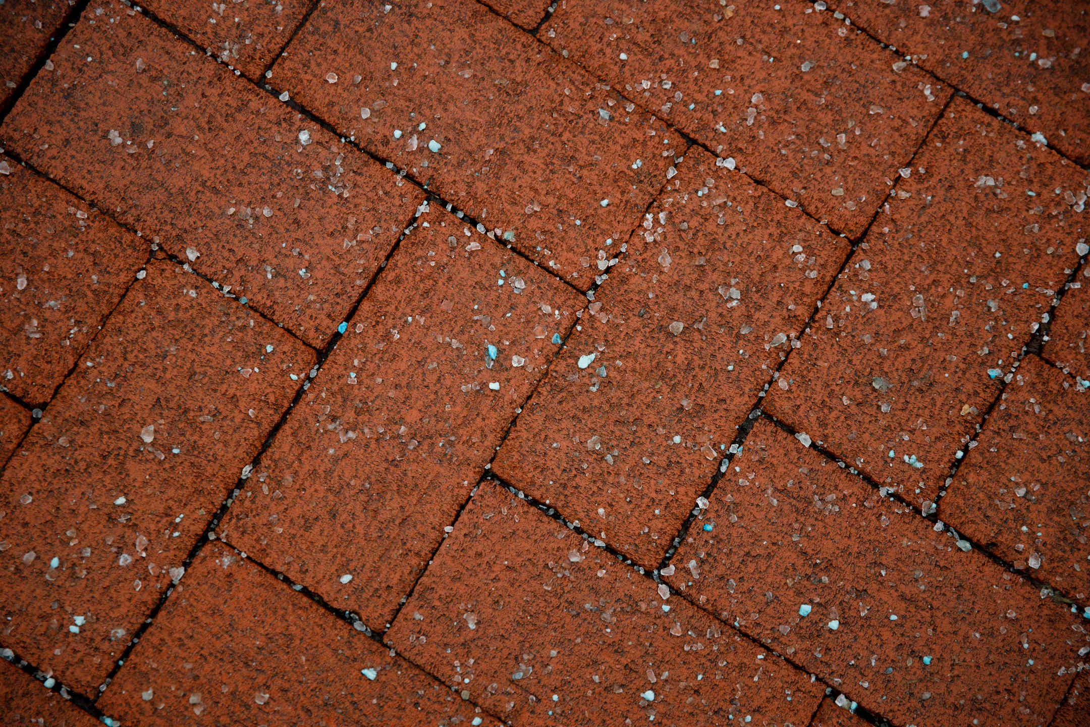 Ice melt crystals (salt) covers a brick walkway in the Old Crescent on a winter day at Indiana University Bloomington on Wednesday, Feb. 10, 2021.